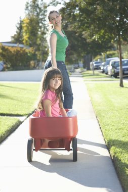 Anne kızını tramvaya çekiyor.