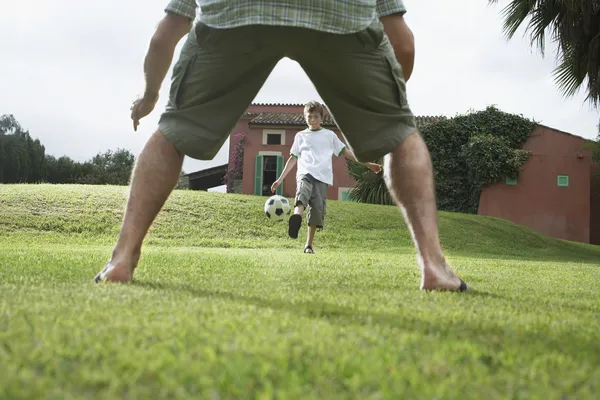 Far och son spelar fotboll — Stockfoto