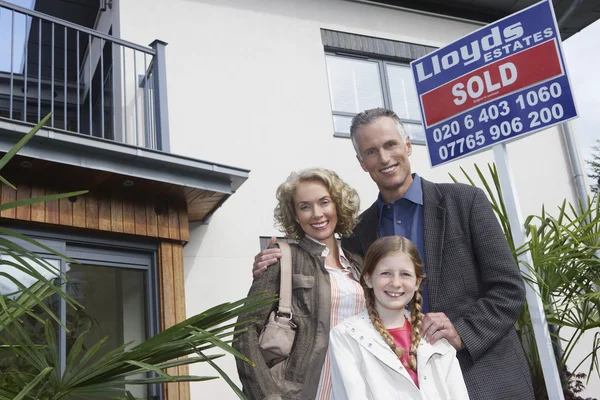 Une famille debout devant chez elle — Photo