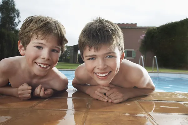 Jongens leunend op de rand van het zwembad — Stockfoto
