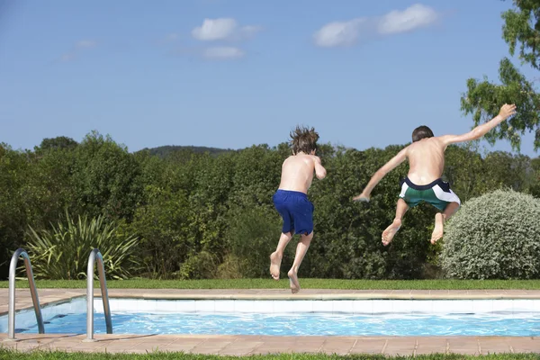 Pojkarna hoppa i poolen — Stockfoto