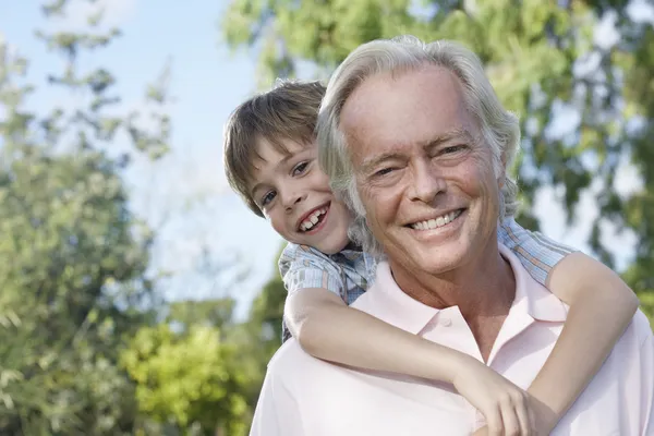 Grandson riding piggy back — Stock Photo, Image