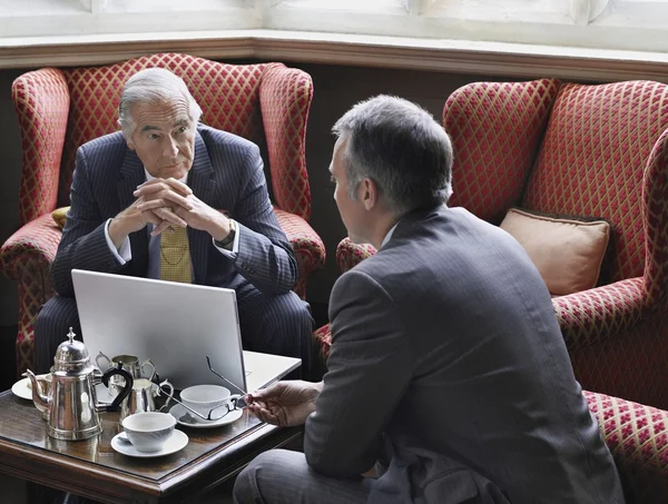 Hombres de negocios hablando con el ordenador portátil — Foto de Stock