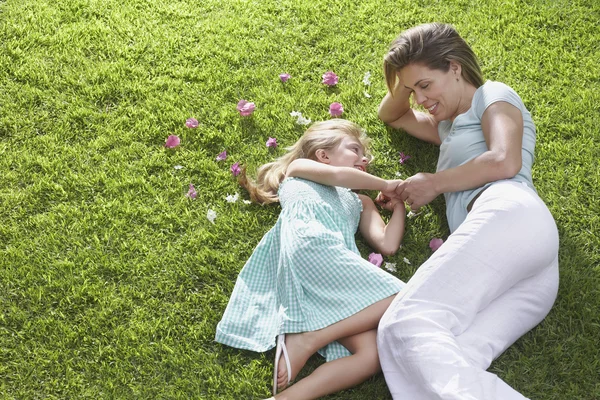 Anne ve kızı çimenlerde yatıyor. — Stok fotoğraf