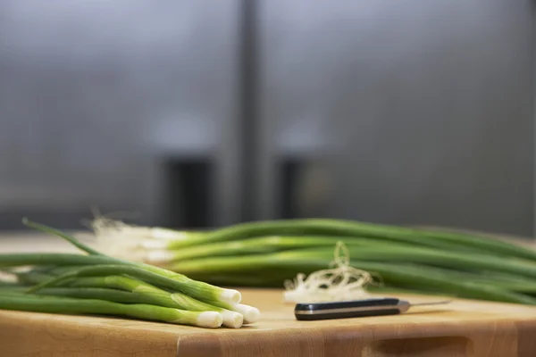 Cebolletas frescas y cuchillo — Foto de Stock