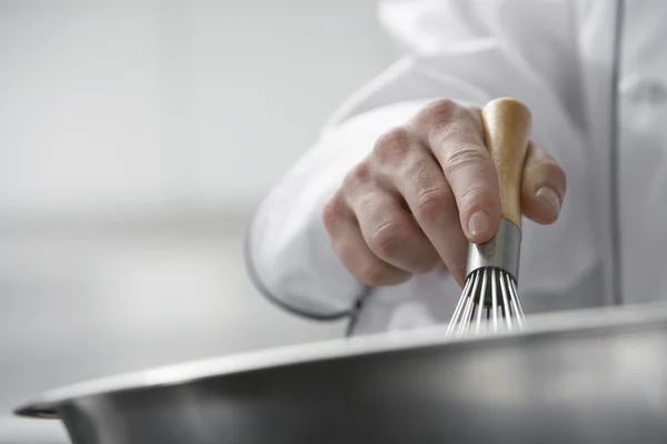 Chef-kok mengen ingrediënten in kom — Stockfoto