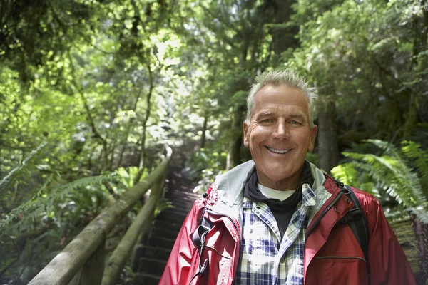 Человек улыбается в лесу — стоковое фото