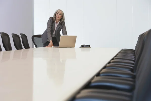 Geschäftsfrau schaut mit Laptop im Sitzungssaal auf — Stockfoto