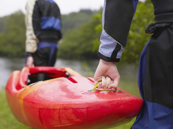 Los hombres que llevan kayak al río —  Fotos de Stock