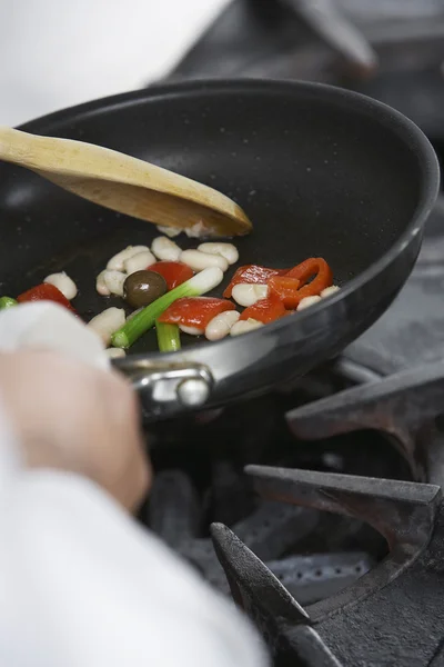 Chef-kok koken voedsel in koekenpan — Stockfoto