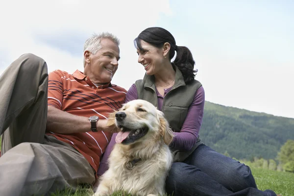 Couple et golden retriever au repos — Photo