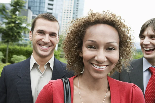 Dos hombres de negocios y una mujer sonriendo — Foto de Stock