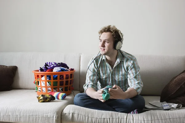 Man holding socks on sofa — Stock Photo, Image