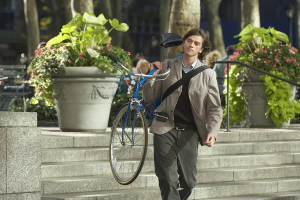 Mann trägt Fahrrad — Stockfoto