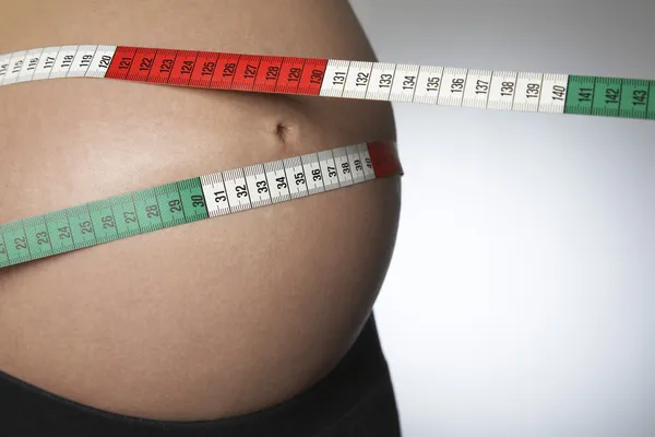 Pregnant woman with tape measure — Stock Photo, Image