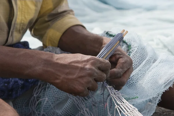 Fisherman mends net — Stock Photo, Image