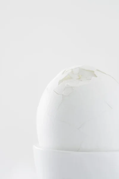 Яйцо со сломанной скорлупой в яичной чашке — стоковое фото