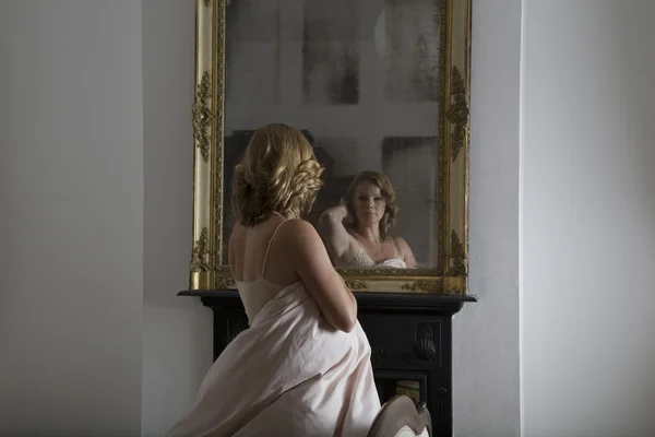 Mujer examinándose en el espejo — Foto de Stock