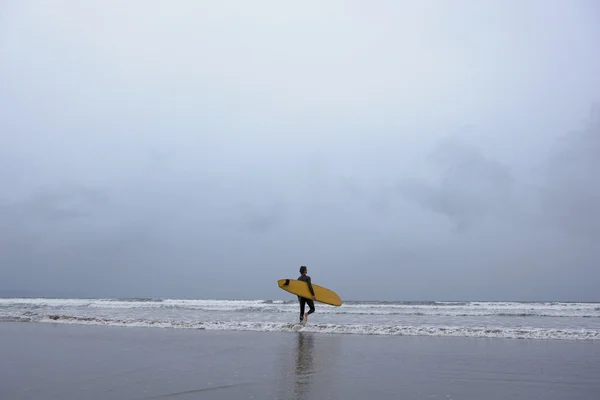 Surfer περπάτημα στο νερό — Φωτογραφία Αρχείου