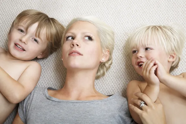 Madre acostada con chicos — Foto de Stock