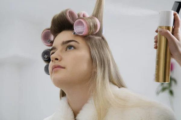Model lässt Haare in Lockenwickler stecken — Stockfoto