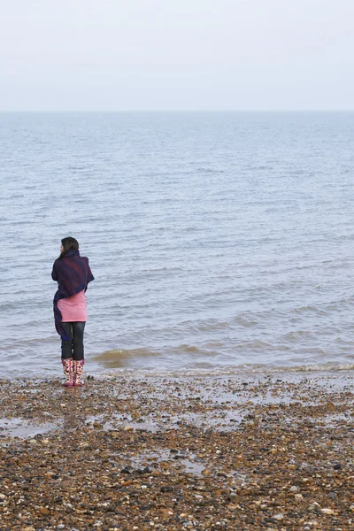 Kvinna stående på stranden — Stockfoto