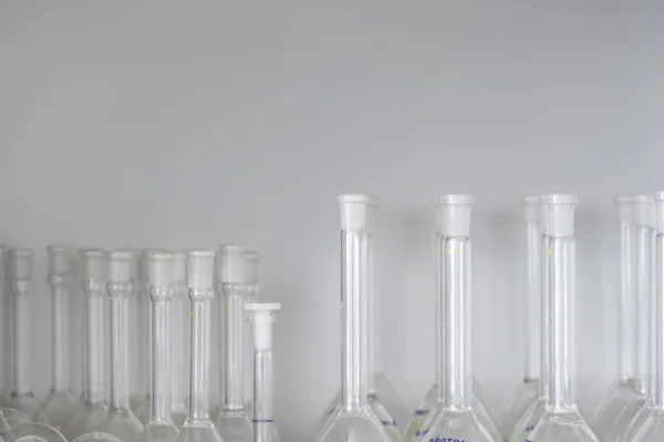 Laboratory flasks on shelf — Stock Photo, Image