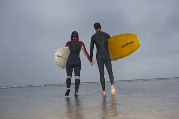 Surfers carrying surfboards — Stock Photo, Image