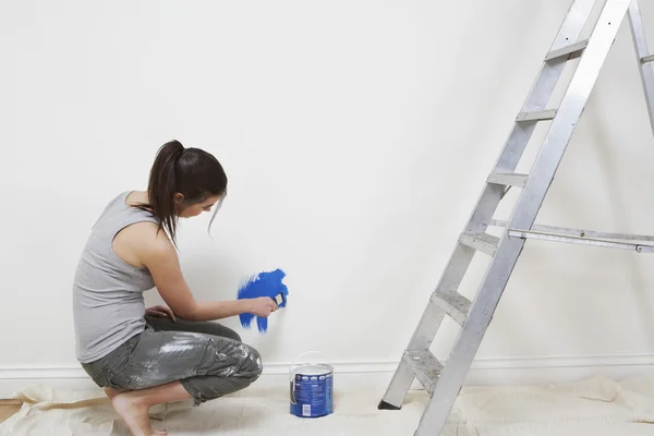 Vrouw schildert muur — Stockfoto