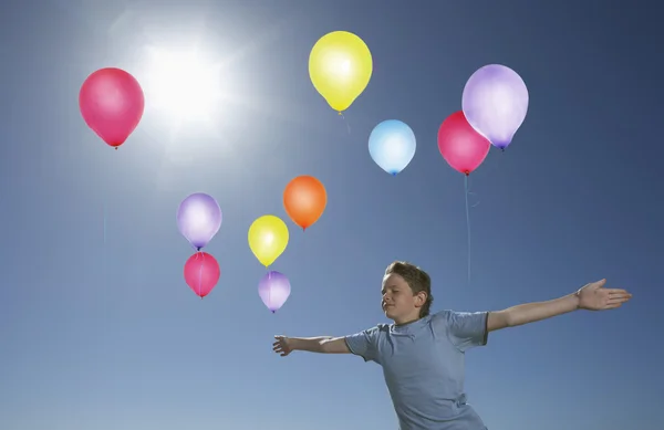 Junge lässt Luftballons steigen — Stockfoto