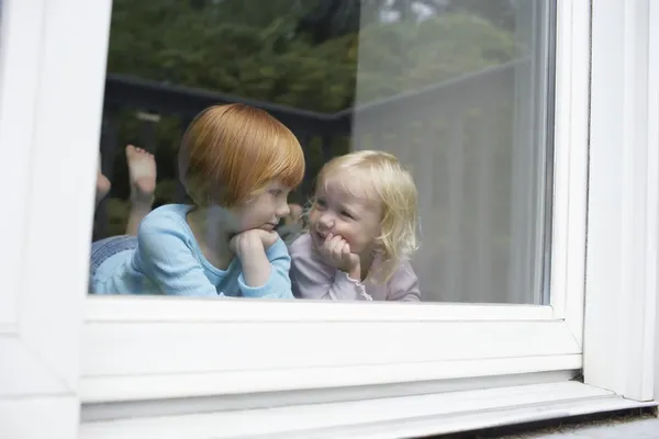 Lilla systrar i fönster — Stockfoto