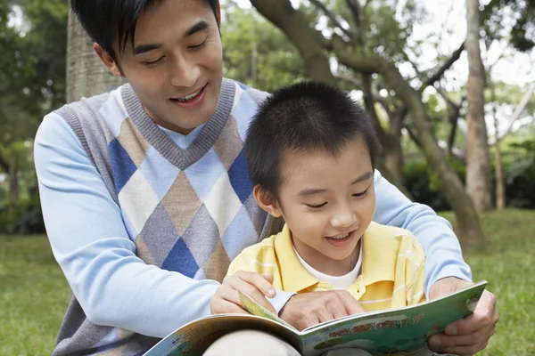 Padre e hijo leyendo libro — Foto de Stock