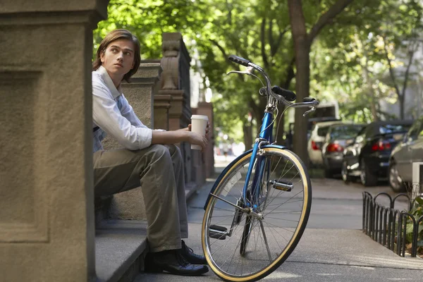Uomo con caffè e bicicletta — Foto Stock