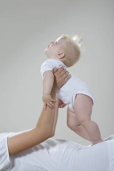 Baby flicka vilar i mors händer — Stockfoto
