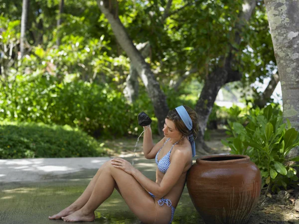 Mujer vertiendo agua en uno mismo — Foto de Stock