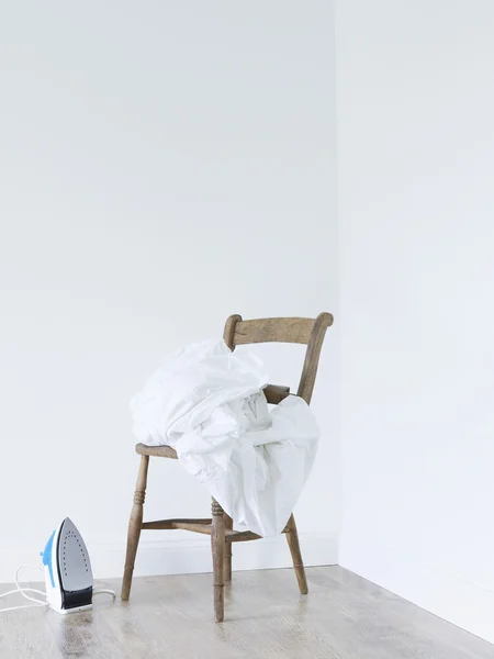 Laundry stacked on chair — Stock Photo, Image