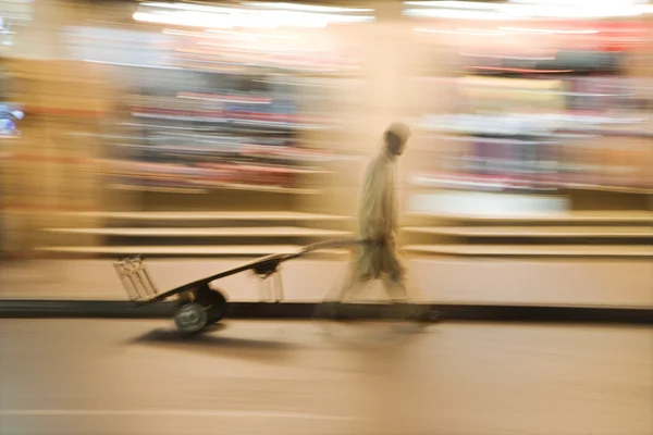 Man wheels an empty cart — Stock Photo, Image