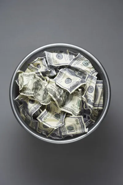 Dollar bills in wastebasket — Stock Photo, Image