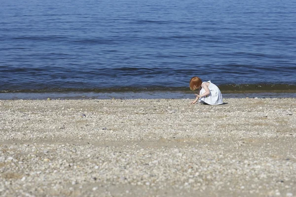 Dziewczyna w kucki na plaży — Zdjęcie stockowe