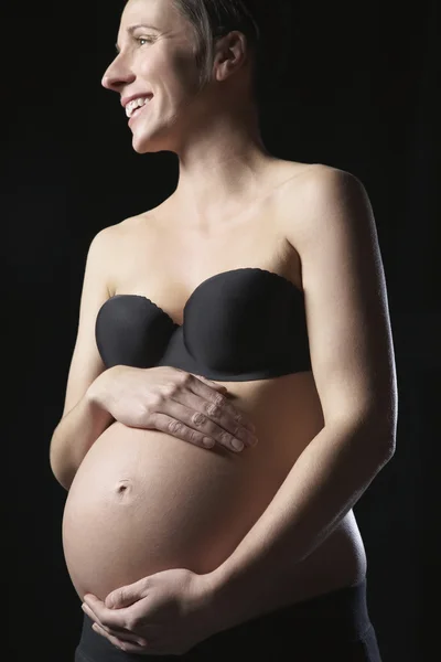 Mujer embarazada tocando el abdomen —  Fotos de Stock