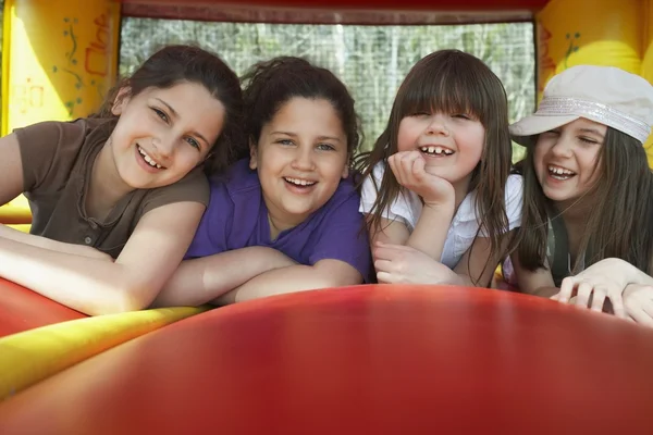 Meninas deitadas em fila no castelo bouncy — Fotografia de Stock