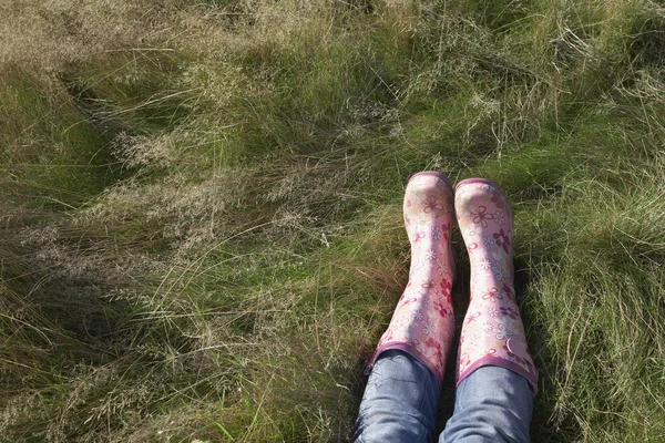 Persoon draagt roze galoshes — Stockfoto