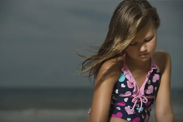 Ragazzina triste su una spiaggia — Foto Stock