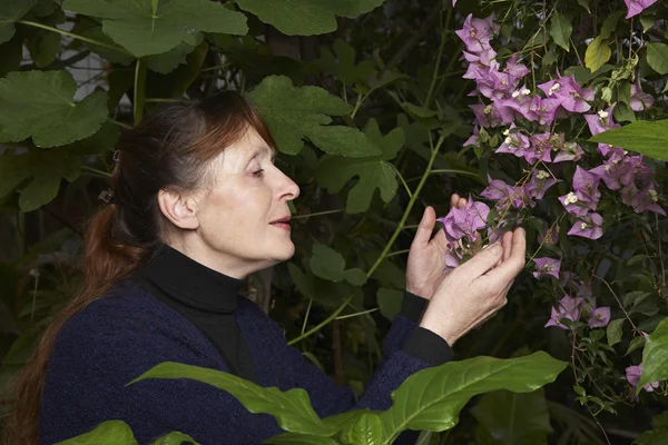 Frau untersucht Blumen — Stockfoto