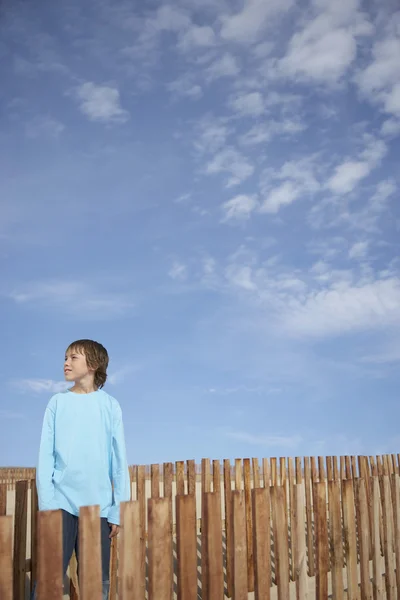 木製フェンスとの間に立っている少年 — ストック写真