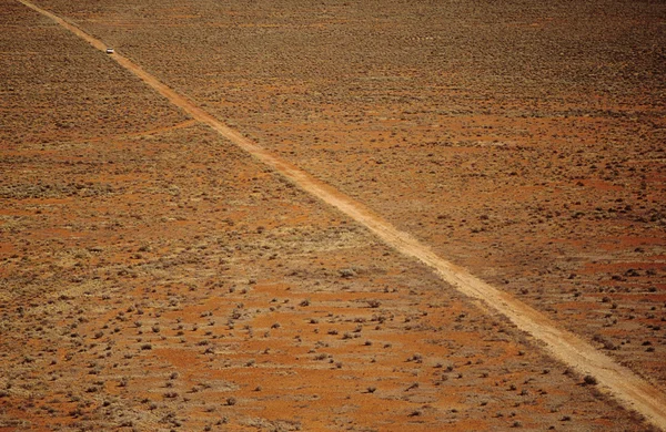 Carro dirigindo ao longo da estrada deserto — Fotografia de Stock