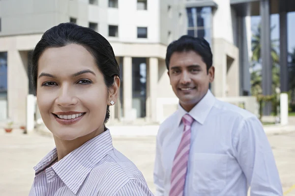 Бизнесмен и деловая женщина улыбаются — стоковое фото