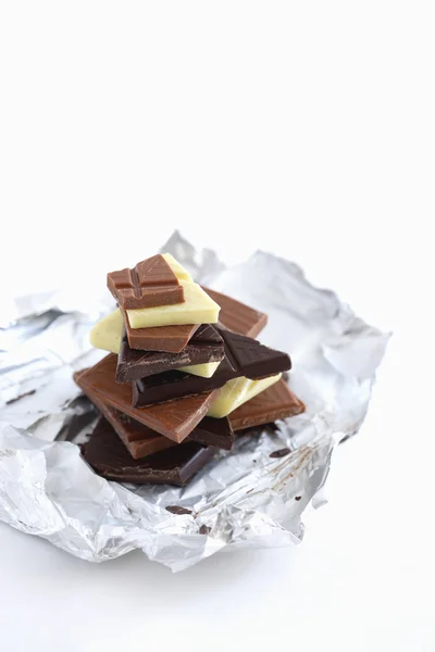 Schokoladenstücke auf Alufolie — Stockfoto