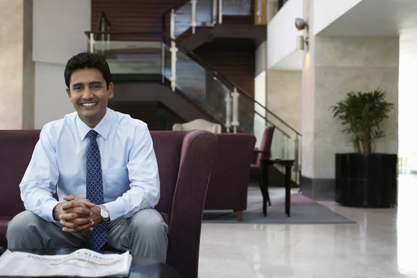 Businessman sitting on sofa — Stock Photo, Image