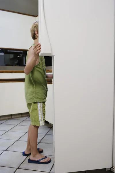 Rapaz a olhar para o frigorífico — Fotografia de Stock